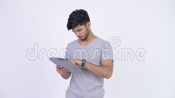 年轻的压力大留着胡子的印度男人使用数字平板电脑得到坏消息视频的预览图