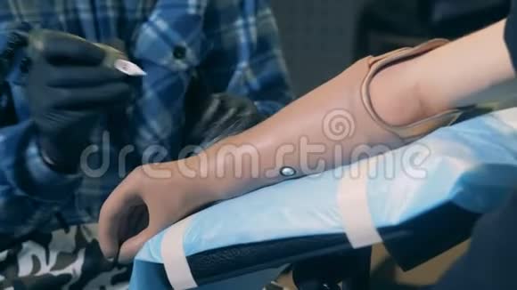 一个残疾人在沙龙里在假肢上纹身视频的预览图