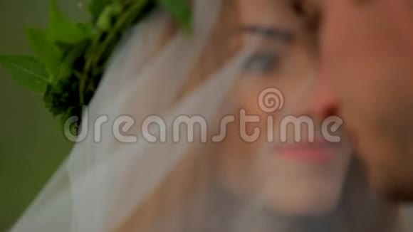 一位戴着面纱的美丽新娘和一位新郎在婚礼当天的画像视频的预览图