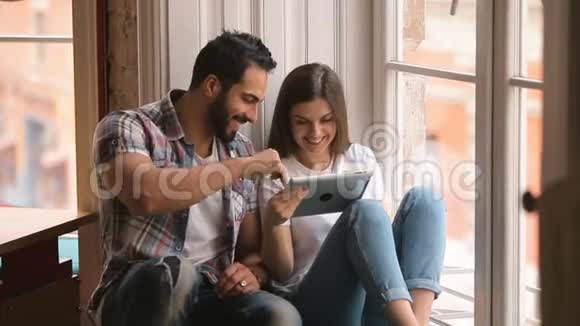 快乐的一对夫妇玩平板电脑视频的预览图