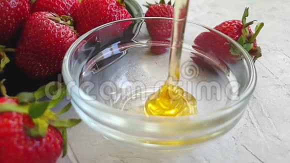 新鲜蜂蜜滴着草莓美味的慢动作视频的预览图