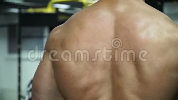 肌肉男健美者用背部摆姿势视频的预览图