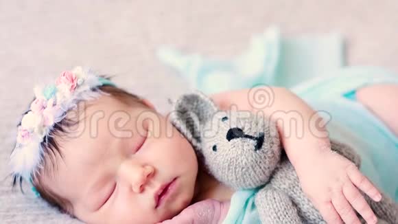 可爱的新生婴儿躺在床上与最喜欢的毛绒玩具视频的预览图