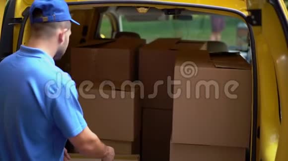 穿蓝色制服的快递员把箱子装进车里视频的预览图