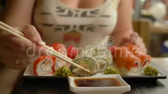 传统的日本料理饥饿的女人在餐馆吃酱油寿司视频的预览图