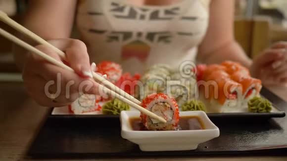 日本菜年轻女性在餐馆用棍子吃酱油卷视频的预览图