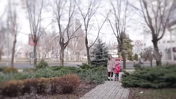 一个带着妈妈的小女孩在冬天的城市里散步时兴高采烈地说着视频的预览图