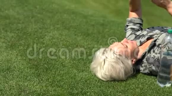 金发女人躺在草地上视频的预览图