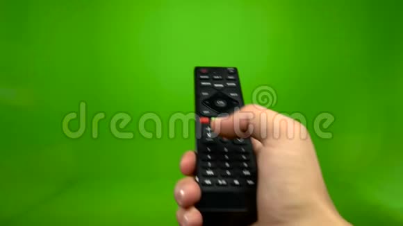 男性手在绿色屏幕上操作电视遥控器视频的预览图