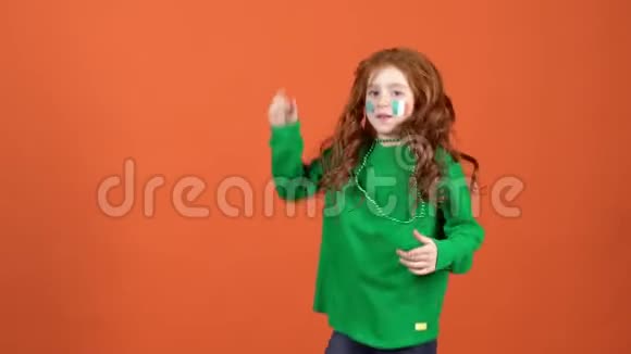 女孩红发庆祝圣帕特里克天橙色背景令人高兴视频的预览图