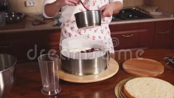 家庭主妇在做甜点的时候在蛋糕上撒了一道红甜酱视频的预览图
