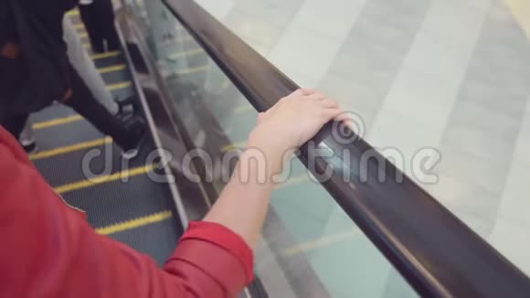 女人的手扶梯扶手上移动4K慢镜头特写视频的预览图