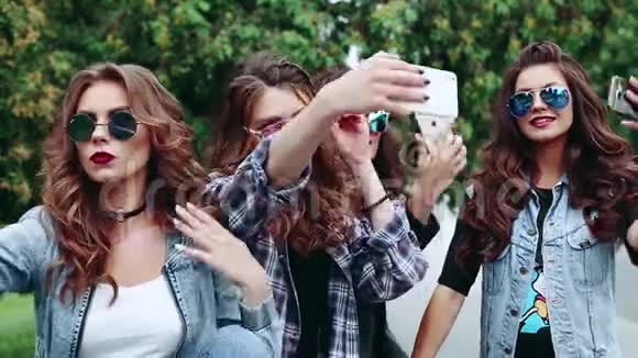 一群美丽时尚的黑发女孩在智能手机上做自我肖像视频的预览图