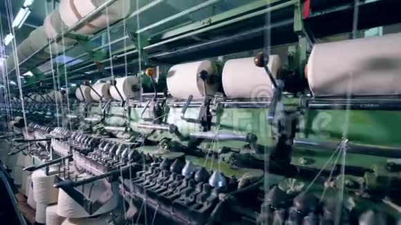 工厂机构是缠绕白色线轴纺织针织设备在一个生产工厂视频的预览图