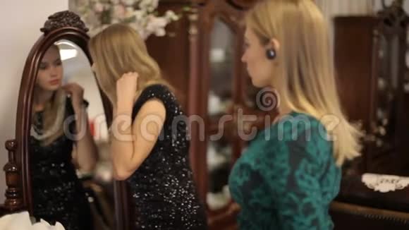 在别致的房间里两个漂亮的女孩在镜子前选择珠宝视频的预览图