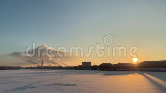 日落时分冰雪覆盖的城市上空的冬季工业景观视频的预览图