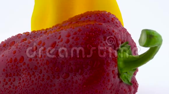 超级特写的两个甜辣椒黄色和红色的水滴在转盘上旋转孤立视频的预览图