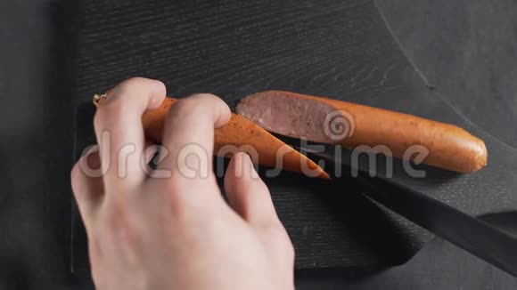 厨师在木板上用锋利的刀切香肠做食物香肠和肉在厨房做饭视频的预览图