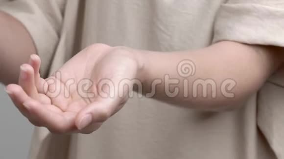 一个年轻的女人在手腕上涂薰衣草油然后把它擦到皮肤上顺时针运动的特写视频的预览图