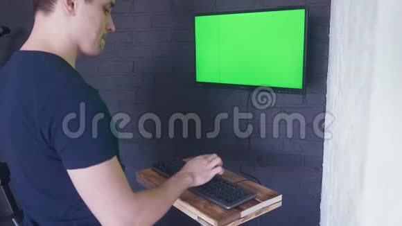 年轻人正在用一个绿色屏幕模拟电脑工作4K按键盘上的一个按钮删除视频的预览图