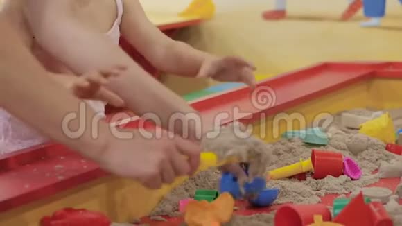 妈妈带着一个小孩在一个沙箱里玩沙箱里有动沙用砂子填充模具并制作砂型视频的预览图