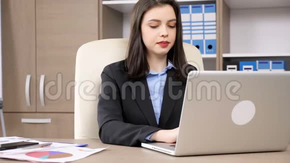 女商人正在用手提电脑打字然后接电话视频的预览图