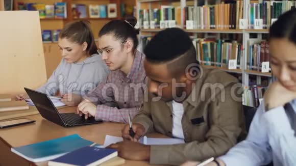 在大学图书馆准备考试的时候把注意力集中在戴眼镜的时髦男学生身上视频的预览图