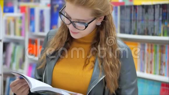 幸福美丽的少女眼镜中的女孩书库中的学生阅读大学中的女孩视频的预览图