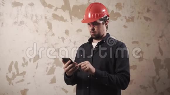 一个男人的肖像手里拿着一部智能手机在一个建筑工地视频的预览图