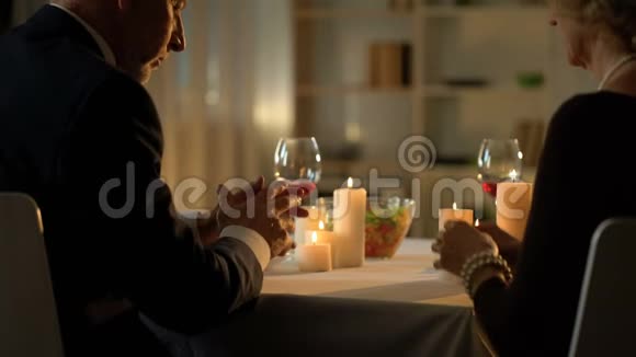 老夫妻饭前祈祷坐在餐桌前吃感恩节晚餐视频的预览图