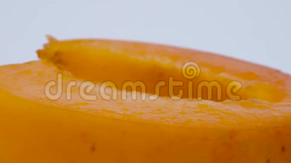 超近宏观的一半杏果在转盘上旋转孤立在白色背景上视频的预览图