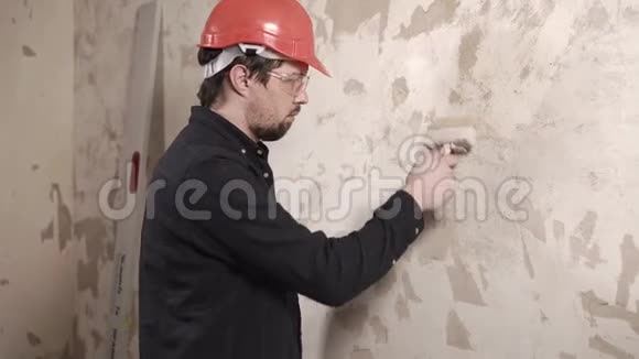 一个男人的肖像一个男人在墙上用胶水粘墙纸视频的预览图