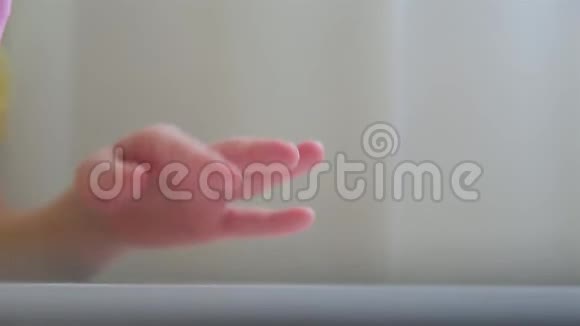 婴儿坐在白色的桌子上玩着粉红色的黏液HD1920x1080视频的预览图