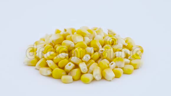 鲜甜玉米粒堆在转盘上旋转孤立在白色背景上特写镜头宏观的视频的预览图