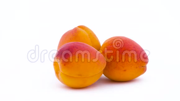 三个杏果在转盘上旋转在白色背景上隔离特写镜头宏观的视频的预览图