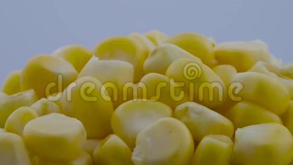 超近宏观的鲜甜玉米粒堆在转盘上旋转孤立在白色背景上视频的预览图