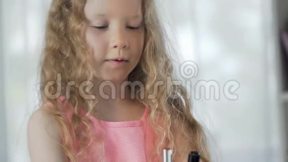 小女孩站在镜子前涂着红色的口红微笑着视频的预览图