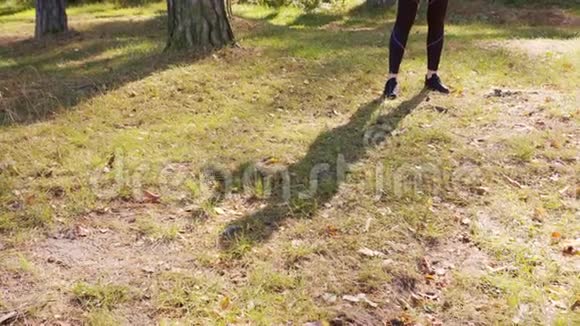 年轻的女士在森林里伸展脚和阴影视图视频的预览图
