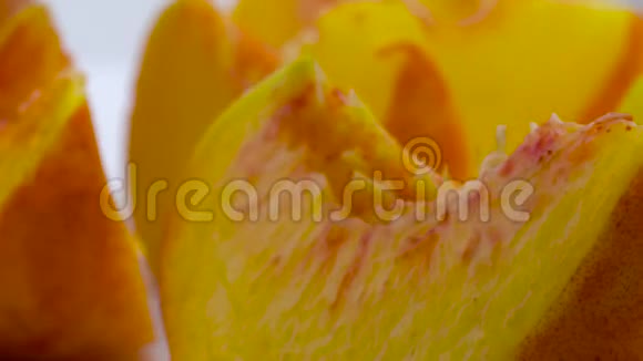 超级接近宏观的桃果片在转盘上旋转孤立在白色背景上视频的预览图