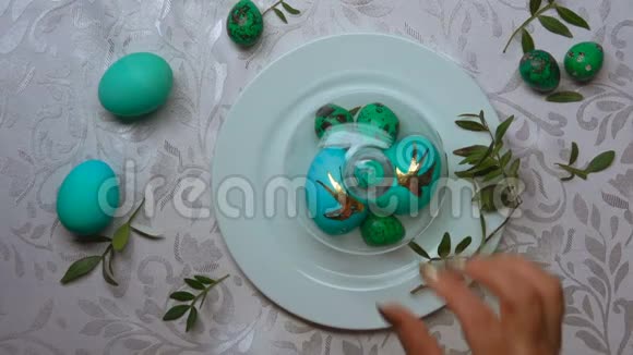 手从装有绿色复活节彩蛋的盘子里取出一个玻璃穹顶视频的预览图