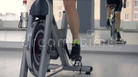 女性腿旋转踏板在静态自行车健身健身房自行车训练视频的预览图