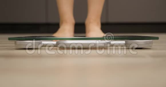 人的脚站在鳞片上紧贴着体重秤上的女人减肥概念视频的预览图