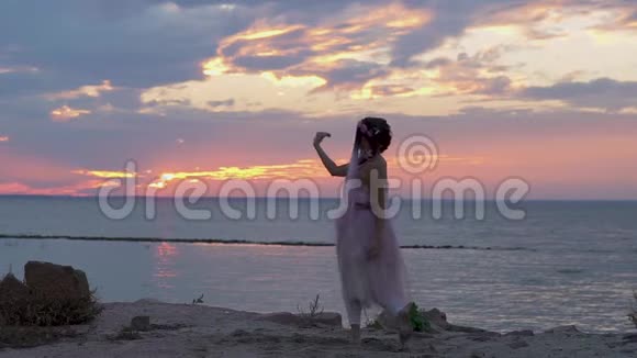 可爱的女孩妆容鲜艳穿着粉红色的连衣裙在河岸上跳舞一个性感女人和一个视频的预览图