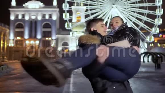 年轻人晚上抱着女友旋转摩天轮背景视频的预览图