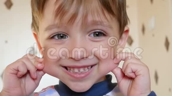 一个孩子男孩高兴地看着相机扭动着鬼脸孩子微笑表现情感视频的预览图