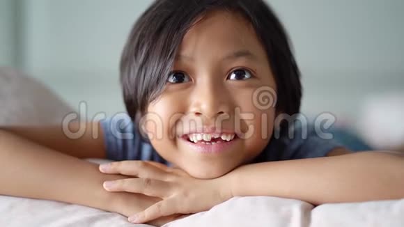 可爱的无牙小女孩在床上微笑视频的预览图