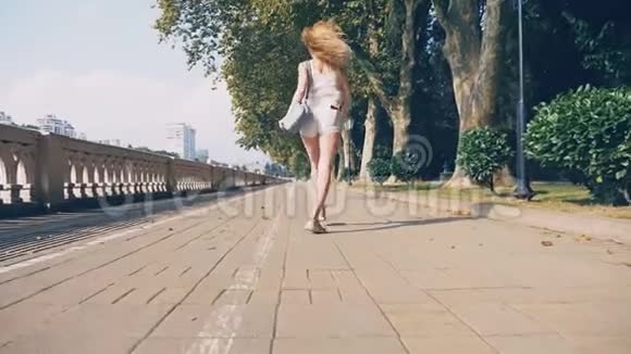 美丽的女孩享受大自然沿着水边的街道奔跑和跳跃很漂亮的年轻女人视频的预览图