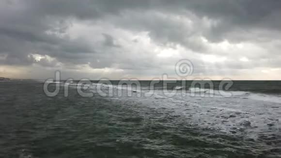 海面上的恶劣天气威胁着海浪拍打着海岸天空阴云密布水面上有阳光照射视频的预览图
