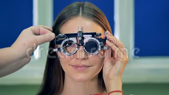 一位年轻女子在视力检查时戴着试镜框视频的预览图
