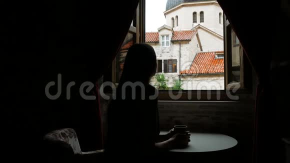 女孩坐在酒店的圆桌旁的窗口视频的预览图